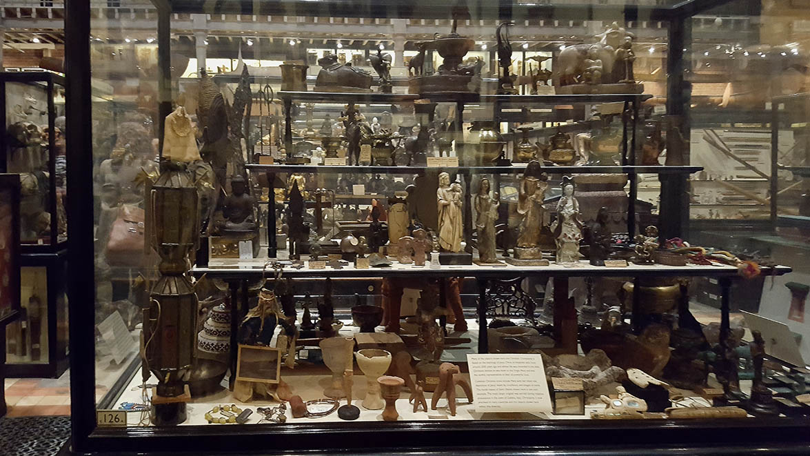 Glass display cabinets full to the brim with antiqities in The Pitt Rivers Museum